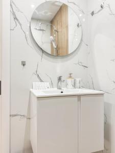 a bathroom with a white sink and a mirror at Skyline Serenity Modern Apartment with Terrace by Flat Manаger in Plovdiv
