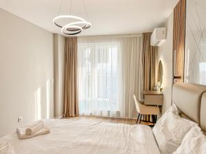 a white bedroom with a bed and a desk at Skyline Serenity Modern Apartment with Terrace by Flat Manаger in Plovdiv