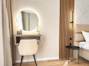 una camera da letto con specchio e sedia accanto a un letto di 1BR Apartment in a Modern Complex a Plovdiv