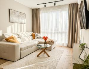 un soggiorno con un divano bianco e un tavolo di 1BR Apartment in a Modern Complex a Plovdiv Altre 19 foto