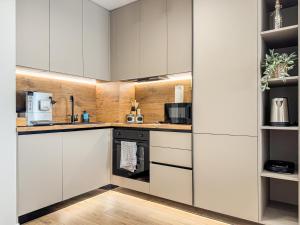a kitchen with white cabinets and a stove at Skyline Serenity Modern Apartment with Terrace by Flat Manаger in Plovdiv +8 photos