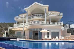 a villa with a swimming pool in front of it at Villa Sunset View Tenerife, Simply Amazing in Adeje