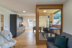 a living room with a couch and a table at Dorfplatzl Suite in Hohentauern