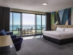 a hotel room with a bed and a view of the ocean at Novotel Geelong in Geelong +130 photos