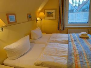 a hotel room with two beds and a window at Ferienwohnung Seeblick 222 in Koserow