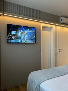 Schlafzimmer mit einem Flachbild-TV an der Wand in der Unterkunft Apartamento 100m da Praia Brava - Itajaí in Itajaí