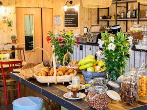 ein Tisch mit Körben voller Brot und Obst darauf in der Unterkunft Greet Hotel Evreux Centre - Route de Normandie by Accor in Évreux