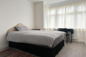a bedroom with a bed and a table and a window at Rehoboth Housing in Cranford