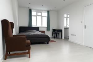 een slaapkamer met een bed en een stoel bij Rehoboth Housing in Cranford