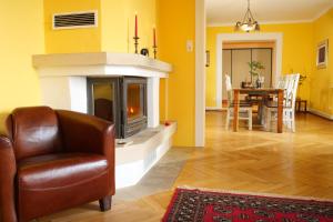 a living room with a chair and a fireplace at Villa Art Residence Überlingen in Überlingen