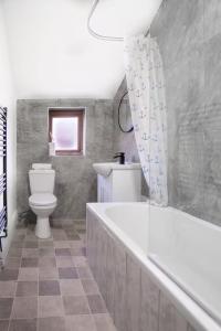 Un baño con bañera blanca y un inodoro. en Mauldeth Shared House, en Mánchester 7 fotos más