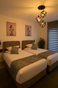a bedroom with two beds and a chandelier at Elegant Ephesus Suites - Hadrian in Selçuk