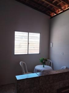 a room with a table and two chairs and a window at Flat Carnaval de Olinda in Olinda +4 photos