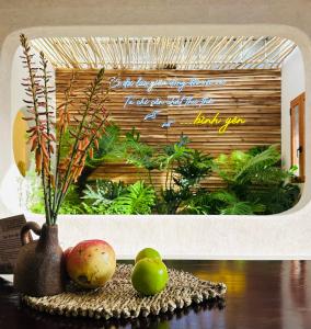 Bình Tích Homestay في Thôn My An: حوض أسماك مع فواكه ونباتات على طاولة