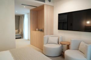 ein Zimmer mit zwei Stühlen und einem Fernseher an der Wand in der Unterkunft At Hotel 35 in Słupca