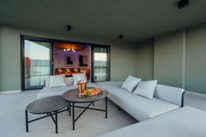 a living room with a white couch and a table at SEAPHORIA Luxury Modern Villa in Trogir +57 photos