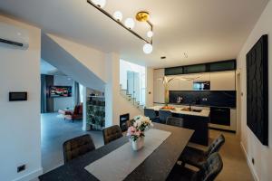 una cucina e una sala da pranzo con tavolo e sedie di SEAPHORIA Luxury Modern Villa a Trogir