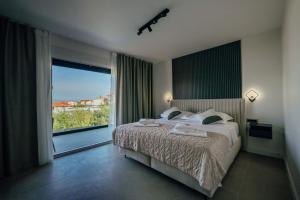 una camera da letto con un letto e una grande finestra di SEAPHORIA Luxury Modern Villa a Trogir Altre 48 foto