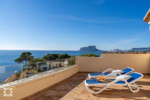 un balcón con una silla de playa y el océano en Villa Gaviota by Abahana Villas, en Cap Blanc