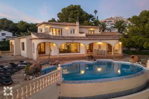 una casa con piscina delante de una casa en Villa Gaviota by Abahana Villas, en Cap Blanc