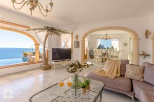 una sala de estar con un sofá y una mesa en Villa Gaviota by Abahana Villas, en Cap Blanc