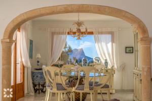 comedor con arco, mesa y sillas en Villa Gaviota by Abahana Villas, en Cap Blanc
