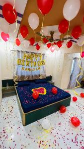 a room with a bed with balloons and a happy birthday sign at Devka House HomeStay in Daman