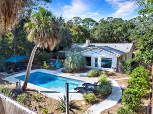 a house with a swimming pool and a palm tree at The Oar House in Tybee Island