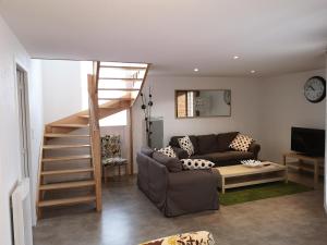a living room with a couch and a staircase at Gites et camping le Sédour in Riom-ès-Montagnes