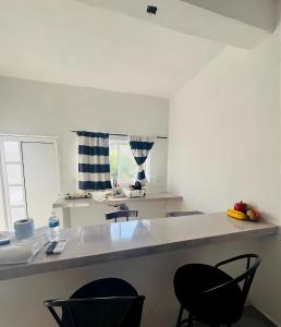 a kitchen with two black chairs and a kitchen counter at El Amanecer de Chiltepec in Chiltepec