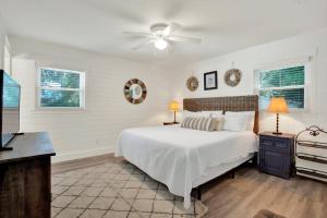a bedroom with a white bed and a ceiling fan at The Oar House in Tybee Island +43 photos