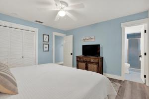 a bedroom with a white bed and a ceiling fan at The Oar House in Tybee Island