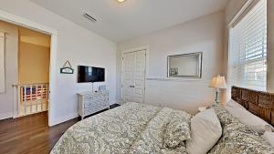 a bedroom with a bed and a flat screen tv at Prominence 30A - Holiday House in Watersound Beach +31 photos