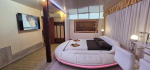 a room with a large white bed and a couch at Love Suite vasca idromassaggio in Bologna