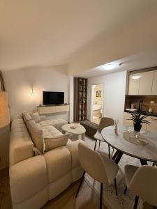 a living room with a large couch and tables at Apartments Konaci Centar in Kopaonik