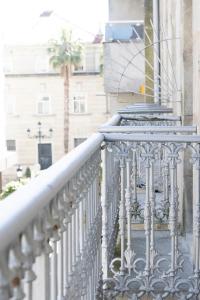 a white railing on a balcony with a palm tree at Hotel Nautico in Vigo