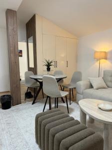 a living room with a couch and a table and chairs at Apartments Konaci Centar in Kopaonik