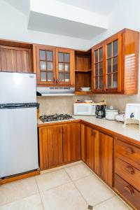 una cucina con mobili in legno e un frigorifero bianco di Agualina Kite Hotel a Cabarete