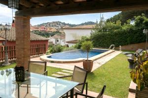 a patio with a table and chairs and a swimming pool at Villa close to the center w pool garden H30 in Begur