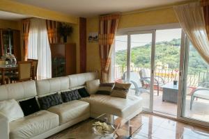 a living room with a white couch and a balcony at Villa close to the center w pool garden H30 in Begur