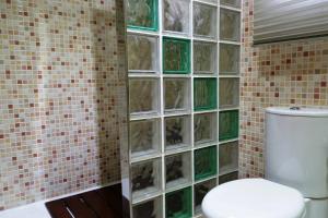 a bathroom with a toilet and a tiled wall at Villa close to the center w pool garden H30 in Begur +15 photos