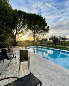 una piscina con dos sillas y una mesa en Le Mas des Vignes en Drome provençale, en Rochegude