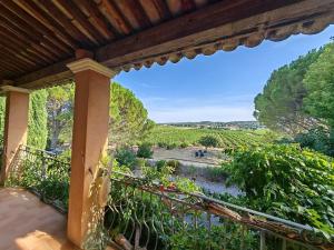 balcón con vistas al río y a los árboles en Le Mas des Vignes en Drome provençale, en Rochegude