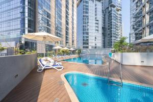 a couple sitting in chairs next to a swimming pool on a building at Urban Chic - Radiant in Abu Dhabi