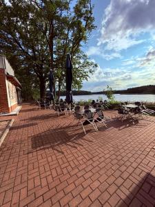 a group of chairs and tables with umbrellas on a brick patio at Waldhaus Weißwasser in Weißwasser