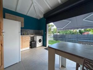 Maison cosy à Sainte-Anne - 31 m² avec terrasse في Douville: مطبخ مع طاولة وغسالة ملابس