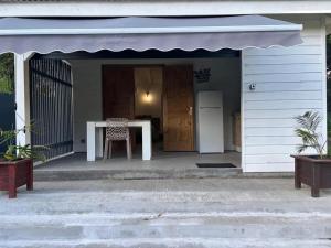 Maison cosy à Sainte-Anne - 31 m² avec terrasse في Douville: بيت صغير مع طاولة وثلاجة