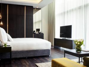 a bedroom with a large bed and a television at Pullman Liverpool in Liverpool
