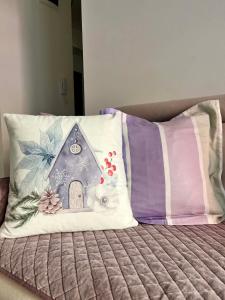 a pillow with a house on it sitting on a bed at Mor Maison Skopje City-Center FEW FREE PRIVATE PARKING in Skopje
