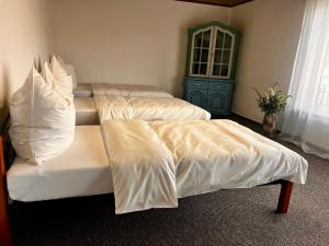 zwei Betten mit weißen Laken in einem Zimmer in der Unterkunft Natascha in Fellen